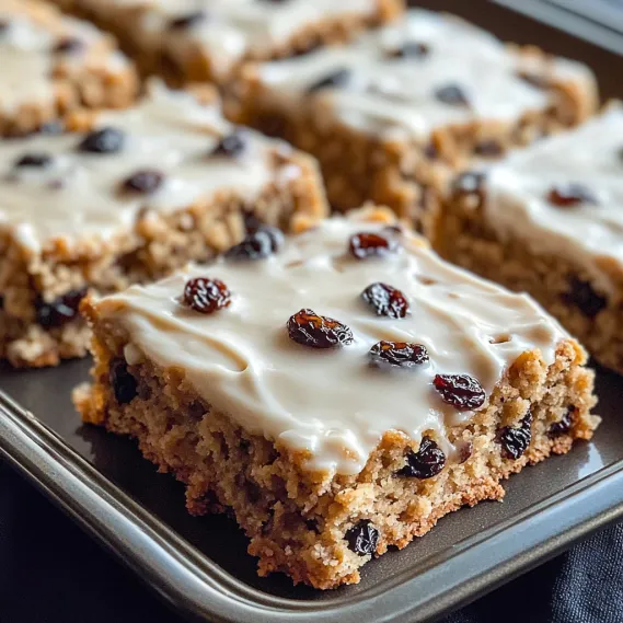 White frosted cake with raisins in a pan.