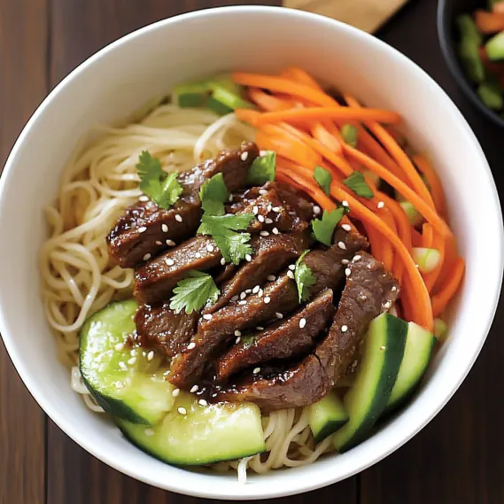 A bowl of noodles with vegetables and meat.