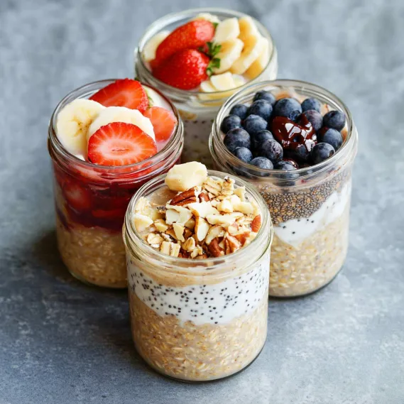 Four food jars sit on a table.
