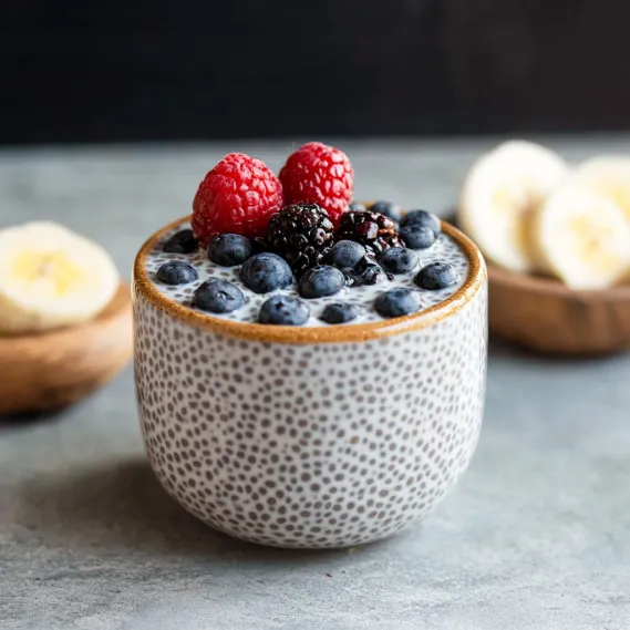 A bowl topped with bananas and berries.