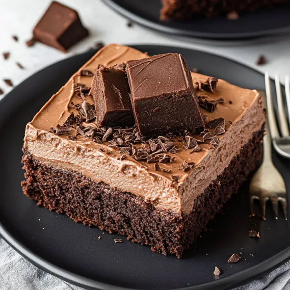 A slice of chocolate cake with chocolate chips on top.