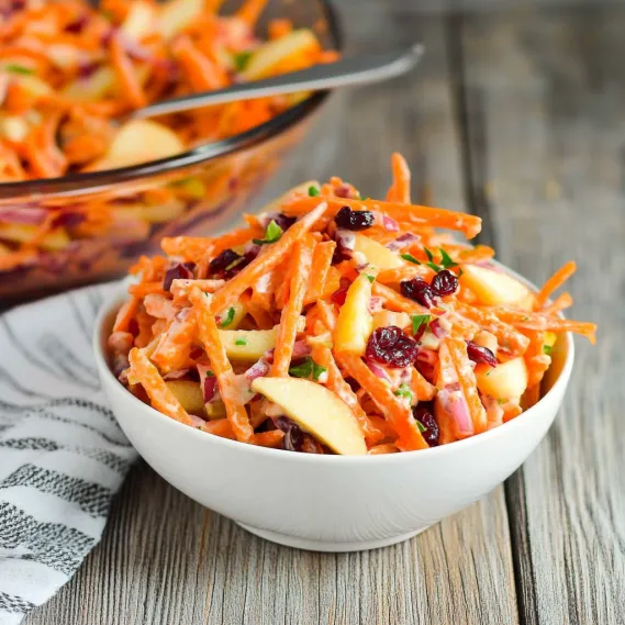 A colorful bowl with crisp carrots and apples.