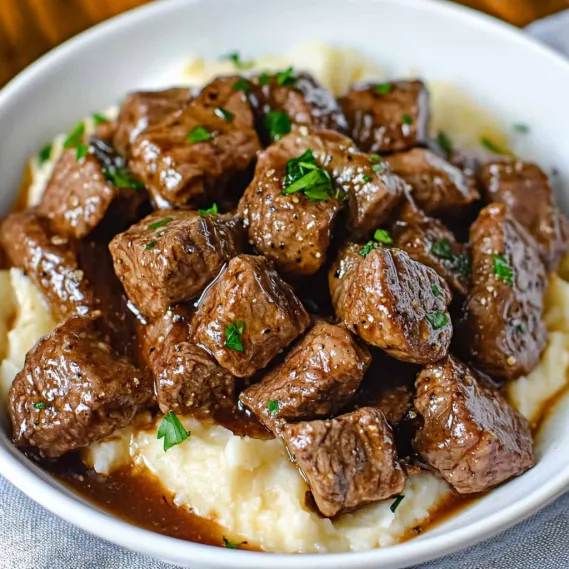 A bowl of tender steak bites and sides.