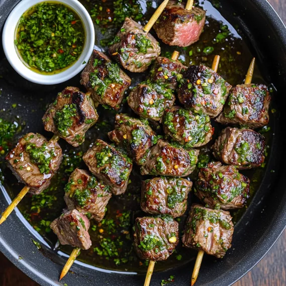 A plate of juicy beef chunks with green herb sauce.
