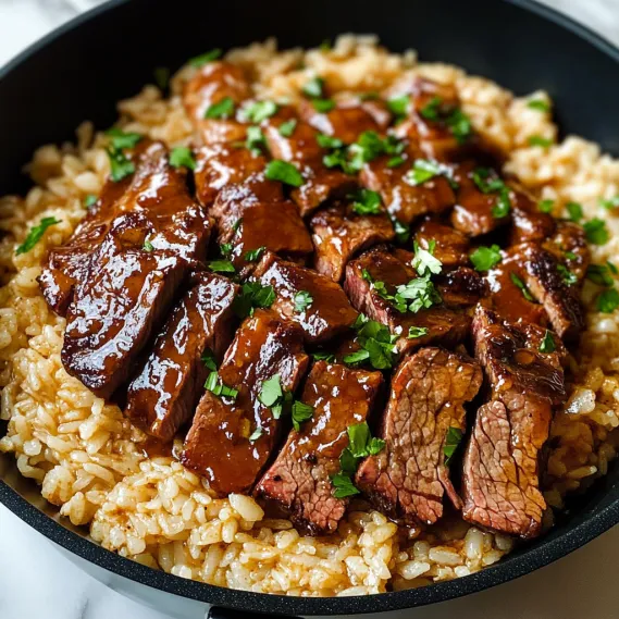A bowl of rice with juicy steak and toppings.