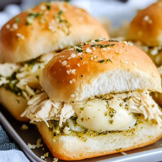 A serving plate full of chicken and cheese-filled sandwiches.