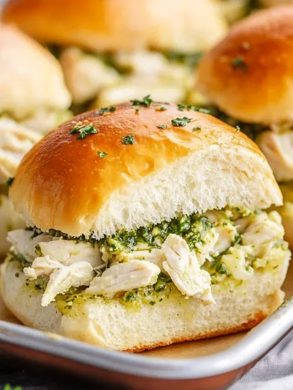 A sandwich with chicken and green stuffing.