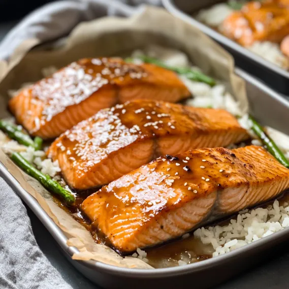 Baked salmon served with rice and seasoning in a pan.