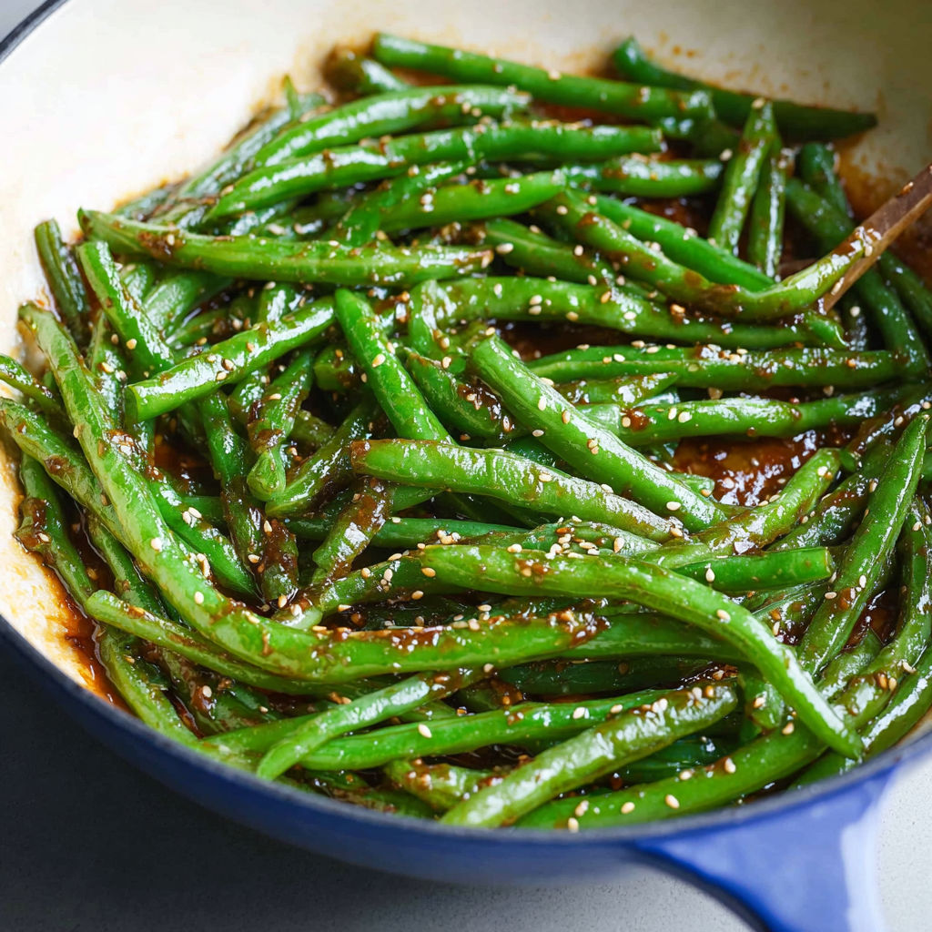 Miso-coated green beans cooking in a skillet.
