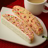A plate stacked with striped cookies in red and white.