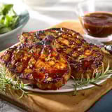 Pork chops served with glaze on a dish.