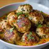 Golden baked meatballs in a savory sauce.