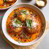 A dish with red sauce and crispy cheese.