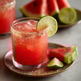 A chilled glass of watermelon margarita with a spiced rim.