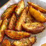 Crunchy potato wedges piled on a plate.