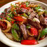 A bowl of sizzling beef and vegetables.