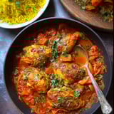 A cozy bowl of Moroccan chicken stew, spoon resting inside.
