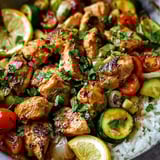 A pan filled with chicken, veggies, and grains.